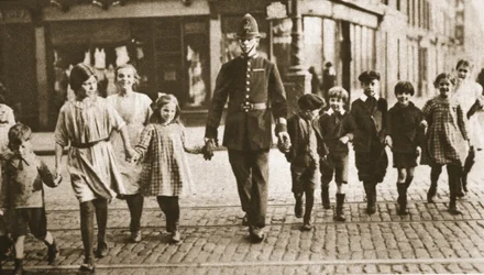 Um bobby na batida ajudando as crianças do outro lado da rua no final do dia letivo, de Wonderful London, publicado em 1926-27 (fotogravura)